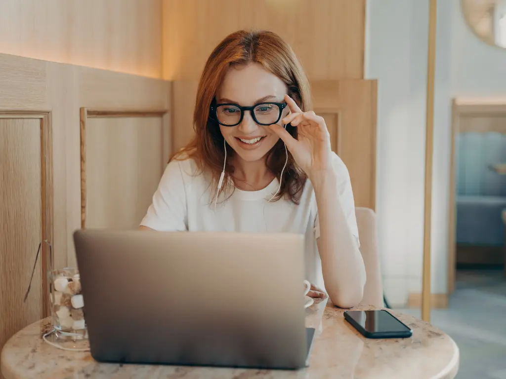 Female smiling navigating a website on laptop